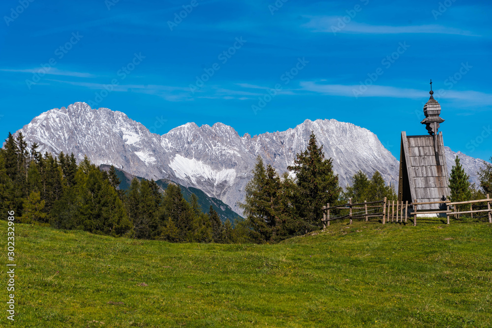 landscape in alps, meadow with wooden chapel in the wetterstein mountains, tyrol landscape in alps, meadow with wooden chapel in the wetterstein mountains, tyrol