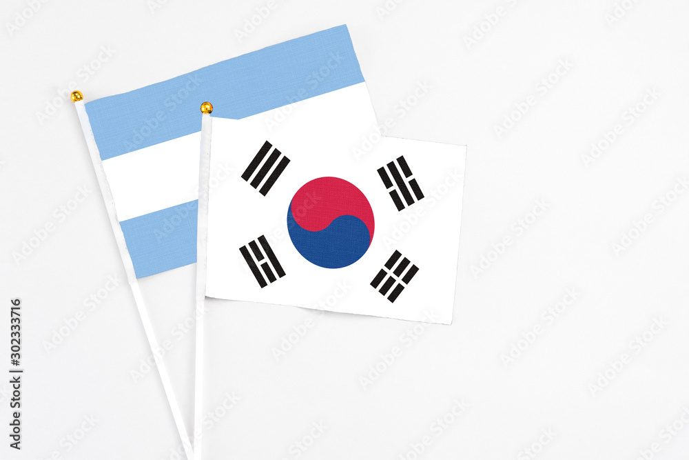 South Korea and Argentina stick flags on white background. High quality fabric, miniature national flag. Peaceful global concept.White floor for copy space.