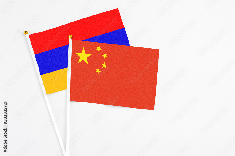 China and Armenia stick flags on white background. High quality fabric, miniature national flag. Peaceful global concept.White floor for copy space.