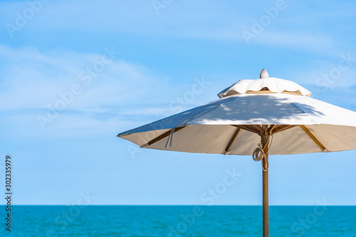 Beautiful umbrella and chair around beach sea ocean with blue sky for travel