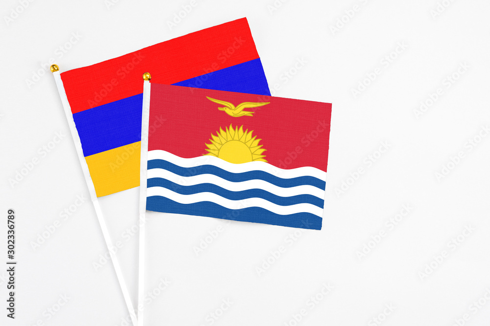 Naklejka premium Kiribati and Armenia stick flags on white background. High quality fabric, miniature national flag. Peaceful global concept.White floor for copy space.