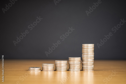 STACKED US QUARTER COINS ON WOODEN SURFACE WITH BLACK BACKGROUND (COPY SPACE)
