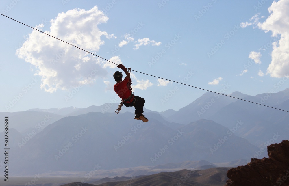 Zipline: man hanging on a rope-way, an exciting adventure Stock