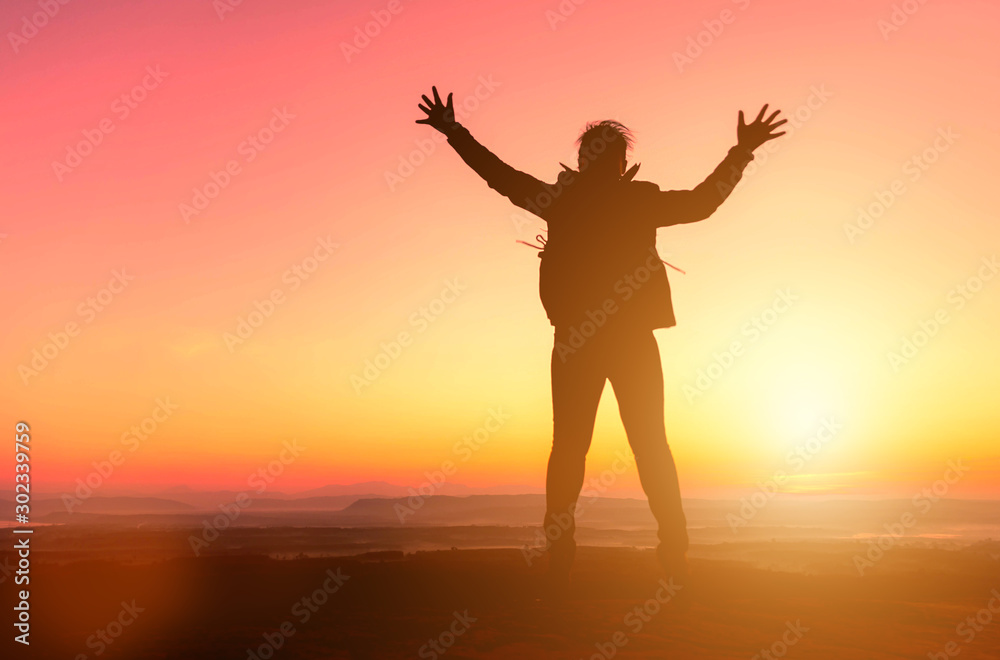 Silhouette of happy girl jumping at sunset background. freedom and enjoying concept.