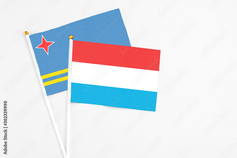 Luxembourg and Aruba stick flags on white background. High quality fabric, miniature national flag. Peaceful global concept.White floor for copy space. Luxembourg and Aruba stick flags on white background. High quality fabric, miniature national flag. Peaceful global concept.White floor for copy space.