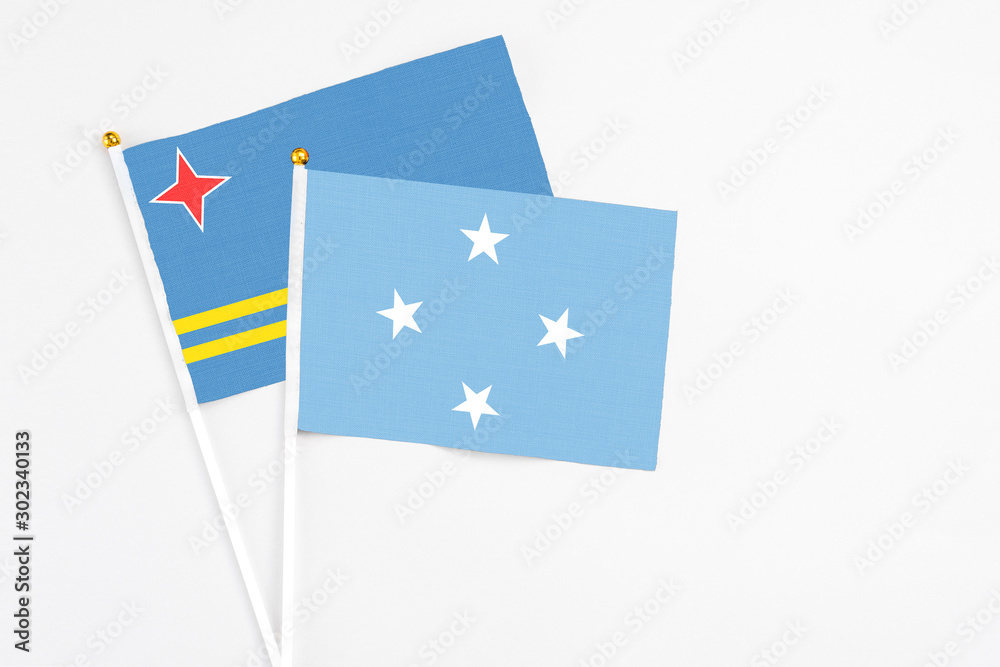 Micronesia and Aruba stick flags on white background. High quality fabric, miniature national flag. Peaceful global concept.White floor for copy space. Micronesia and Aruba stick flags on white background. High quality fabric, miniature national flag. Peaceful global concept.White floor for copy space.