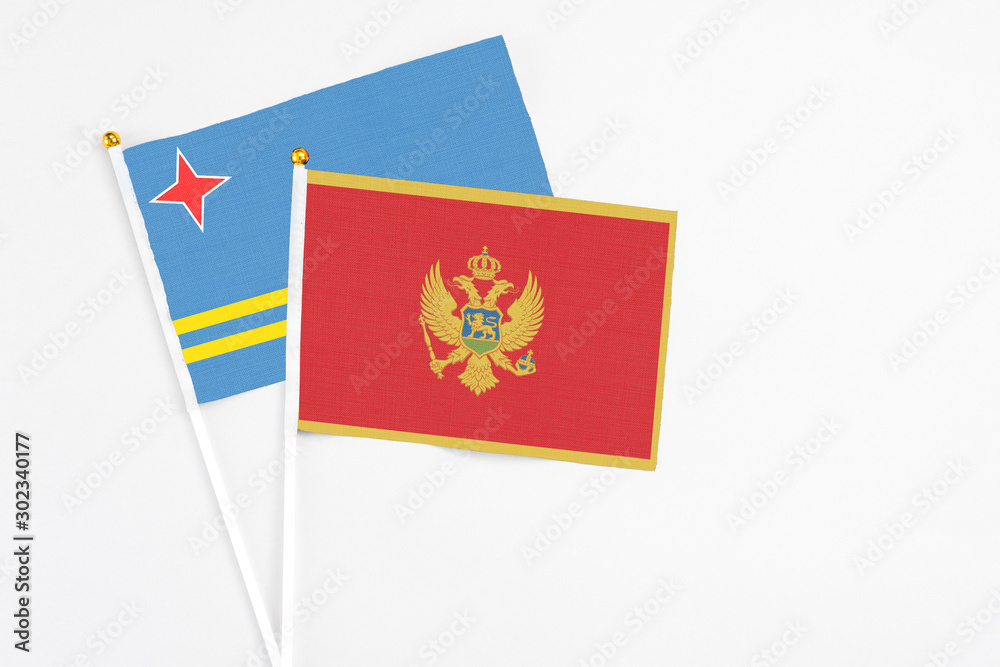 Montenegro and Aruba stick flags on white background. High quality fabric, miniature national flag. Peaceful global concept.White floor for copy space.