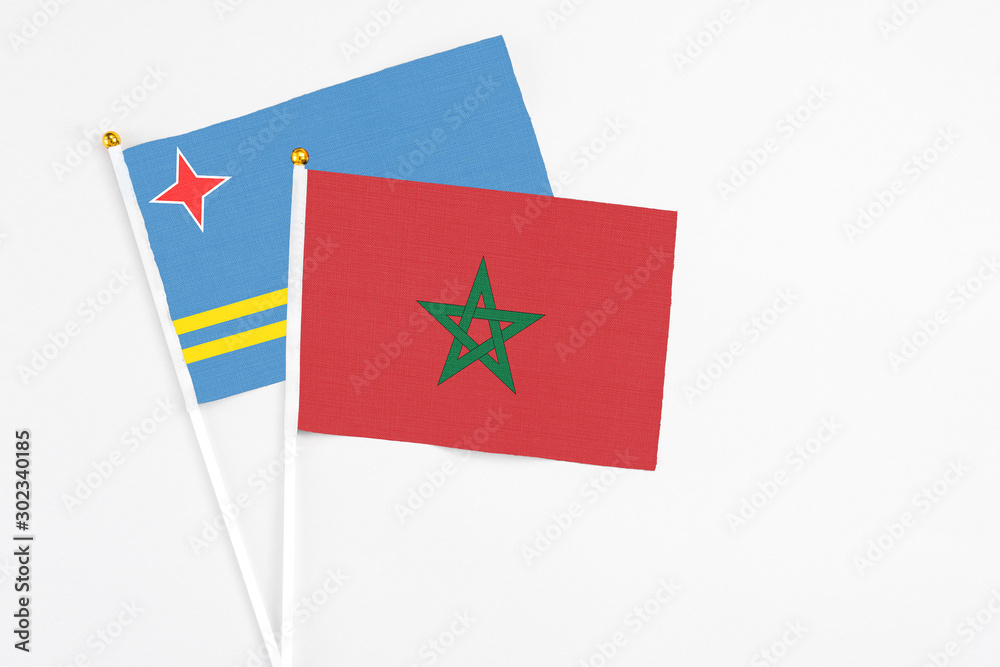 Morocco and Aruba stick flags on white background. High quality fabric, miniature national flag. Peaceful global concept.White floor for copy space.