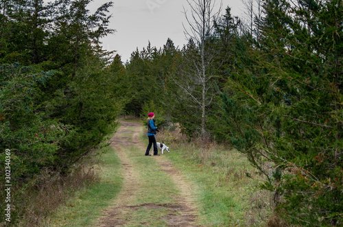 woman walking a dog on a wilderness trail