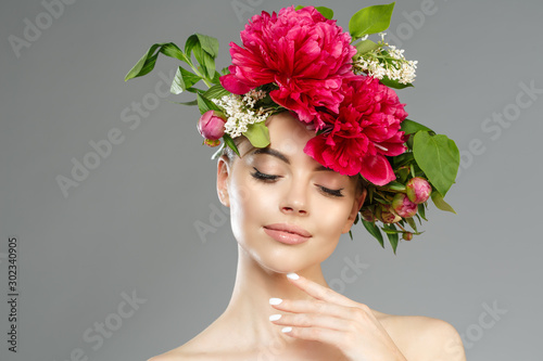 Beauty woman with flowers on head. Happy beautiful girl on gray banner background. Pretty model with clear skin. Spring fashion photo. Summertime portrait