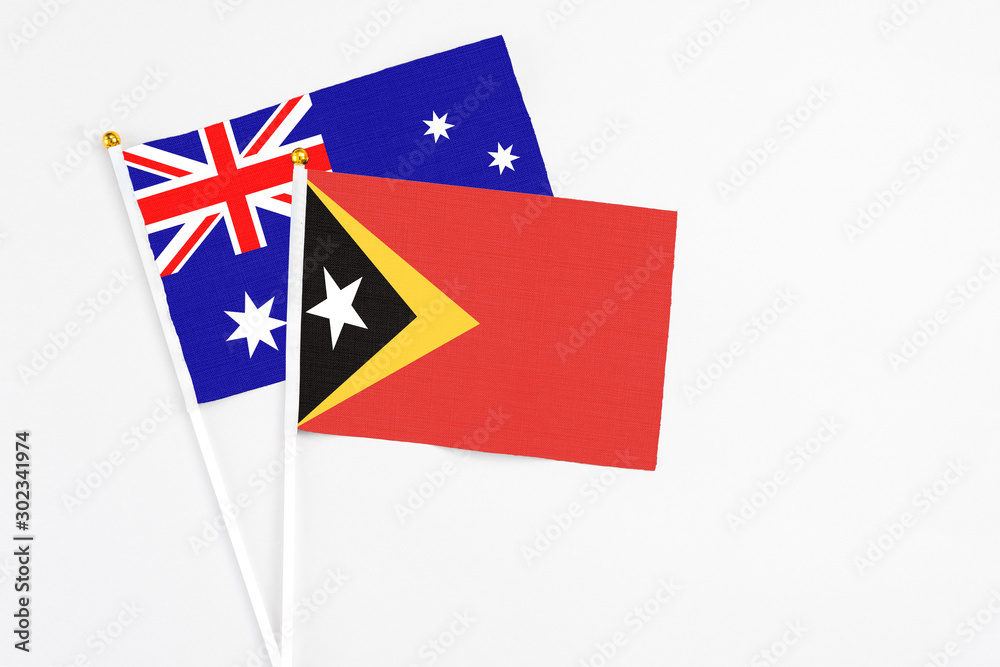 East Timor and Australia stick flags on white background. High quality fabric, miniature national flag. Peaceful global concept.White floor for copy space. East Timor and Australia stick flags on white background. High quality fabric, miniature national flag. Peaceful global concept.White floor for copy space.