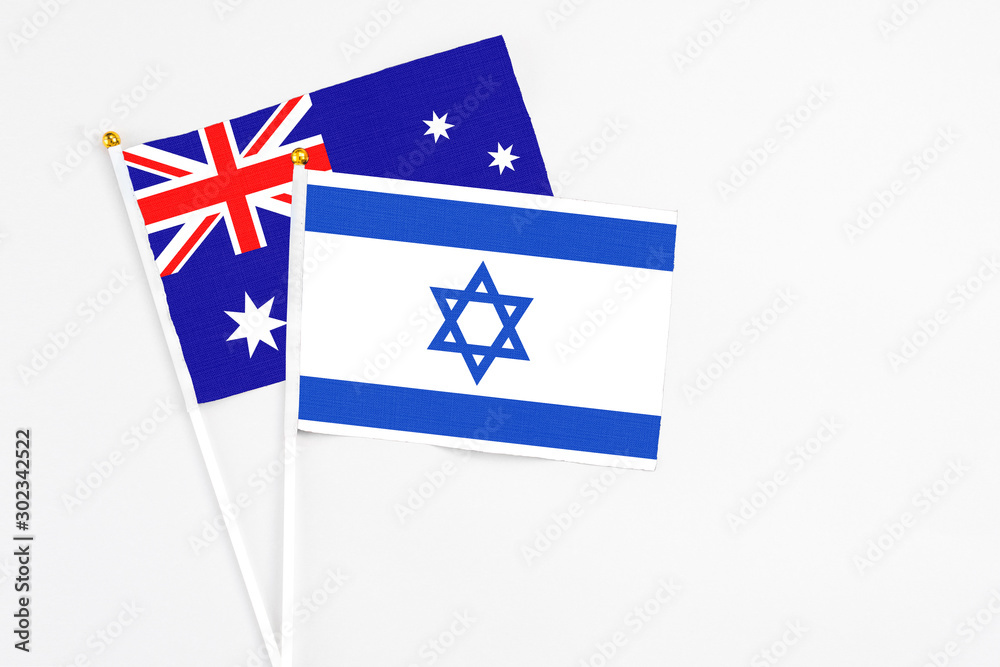 Fototapeta premium Israel and Australia stick flags on white background. High quality fabric, miniature national flag. Peaceful global concept.White floor for copy space.
