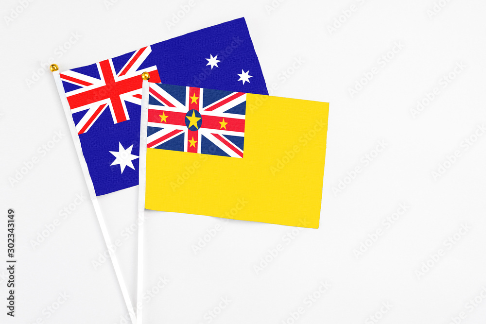Niue and Australia stick flags on white background. High quality fabric, miniature national flag. Peaceful global concept.White floor for copy space. Niue and Australia stick flags on white background. High quality fabric, miniature national flag. Peaceful global concept.White floor for copy space.