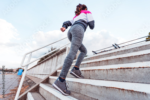 Active female runner running up stairs