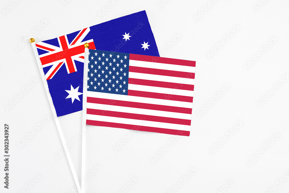 United States and Australia stick flags on white background. High quality fabric, miniature national flag. Peaceful global concept.White floor for copy space. United States and Australia stick flags on white background. High quality fabric, miniature national flag. Peaceful global concept.White floor for copy space.
