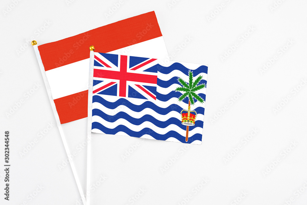 Fototapeta premium British Indian Ocean Territory and Austria stick flags on white background. High quality fabric, miniature national flag. Peaceful global concept.White floor for copy space.