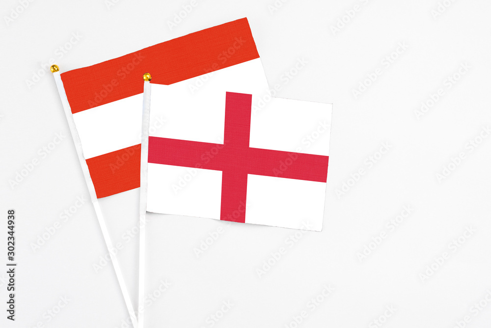 England and Austria stick flags on white background. High quality fabric, miniature national flag. Peaceful global concept.White floor for copy space.