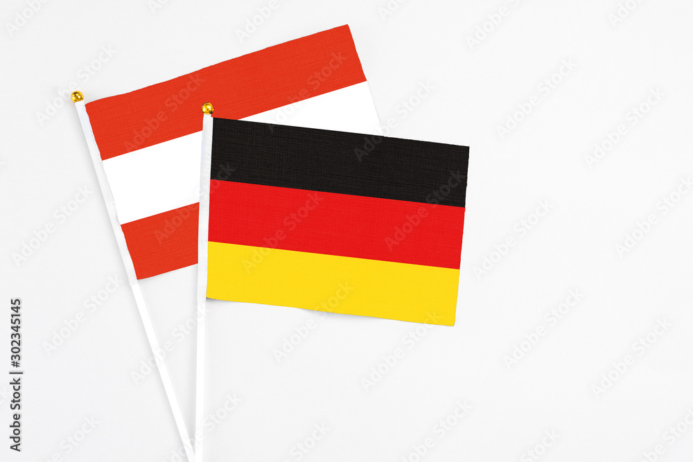 Germany and Austria stick flags on white background. High quality fabric, miniature national flag. Peaceful global concept.White floor for copy space. Germany and Austria stick flags on white background. High quality fabric, miniature national flag. Peaceful global concept.White floor for copy space.