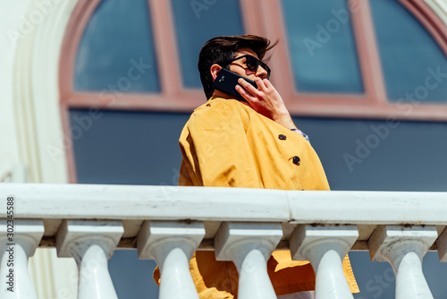 Stylish man with mobile resting on urban place
