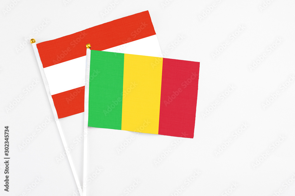 Mali and Austria stick flags on white background. High quality fabric, miniature national flag. Peaceful global concept.White floor for copy space.