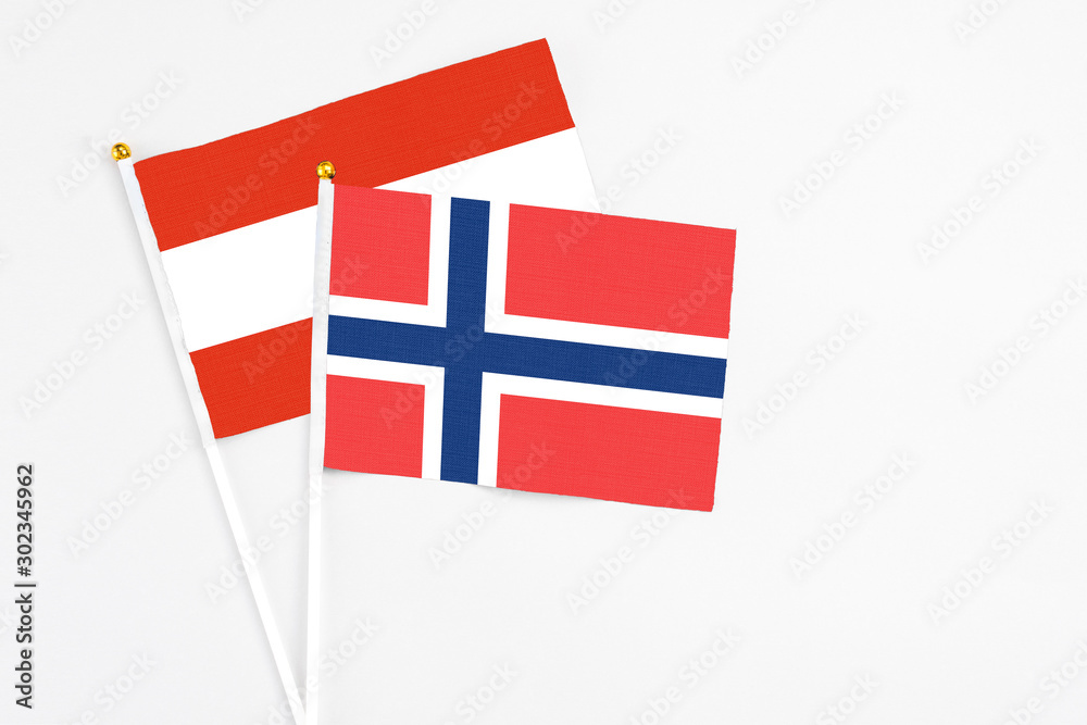 Norway and Austria stick flags on white background. High quality fabric, miniature national flag. Peaceful global concept.White floor for copy space.