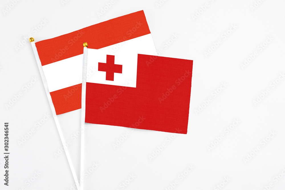 Tonga and Austria stick flags on white background. High quality fabric, miniature national flag. Peaceful global concept.White floor for copy space.