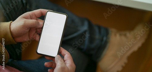 Cropped shot of young man using blank screen smartphone