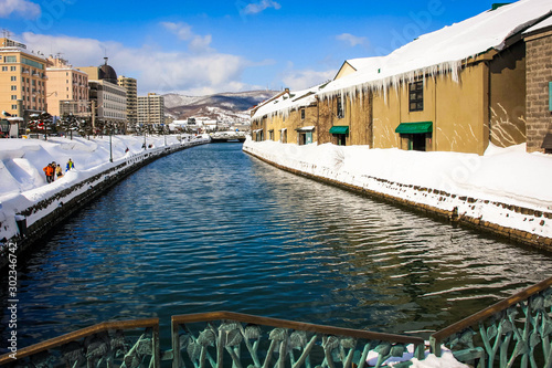 Beautiful scenery of Otaru wearhouses along the Otaru canal in winter with blue sky in background