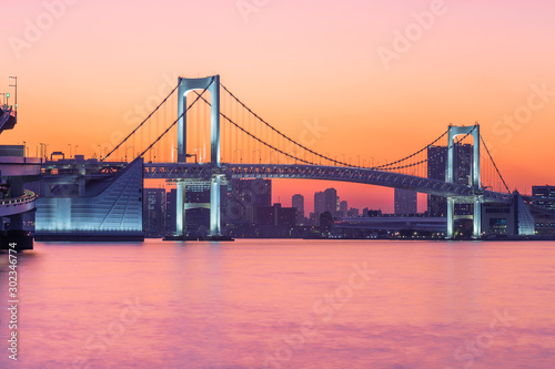 The Rainbow Bridge in Tokyo bay at the purple sunset.
