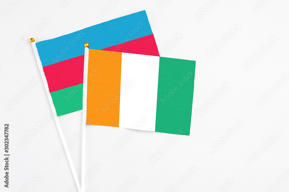 Cote D'Ivoire and Azerbaijan stick flags on white background. High quality fabric, miniature national flag. Peaceful global concept.White floor for copy space. Cote D'Ivoire and Azerbaijan stick flags on white background. High quality fabric, miniature national flag. Peaceful global concept.White floor for copy space.