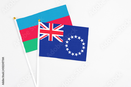 Cook Islands and Azerbaijan stick flags on white background. High quality fabric, miniature national flag. Peaceful global concept.White floor for copy space.