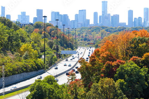 Canvas Print Beautiful colourful fall leaves in the city, autumn foliage with city highway in