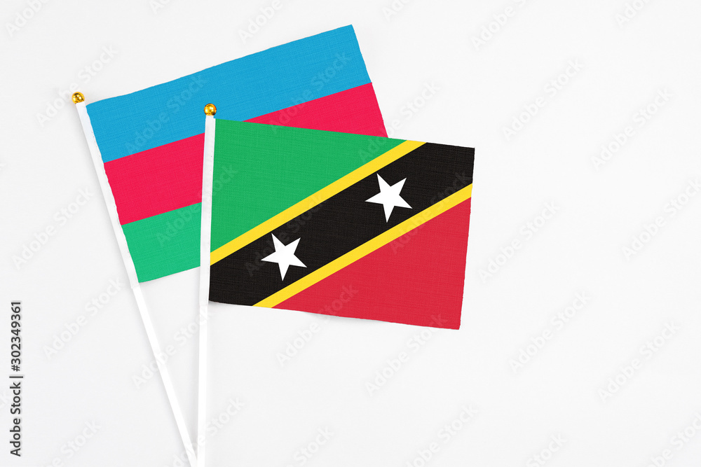 Saint Kitts And Nevis and Azerbaijan stick flags on white background. High quality fabric, miniature national flag. Peaceful global concept.White floor for copy space.