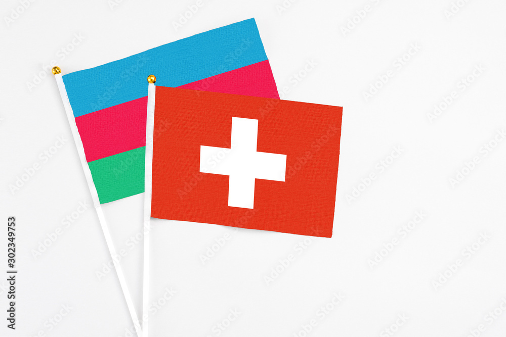 Switzerland and Azerbaijan stick flags on white background. High quality fabric, miniature national flag. Peaceful global concept.White floor for copy space.
