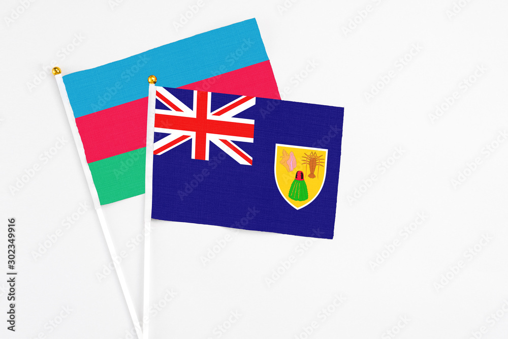 Fototapeta premium Turks And Caicos Islands and Azerbaijan stick flags on white background. High quality fabric, miniature national flag. Peaceful global concept.White floor for copy space.
