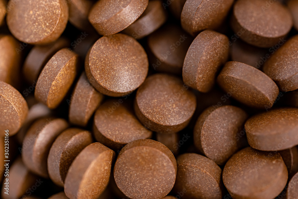 Brown iron supplement pills in the hands Brown iron supplement pills in the hands