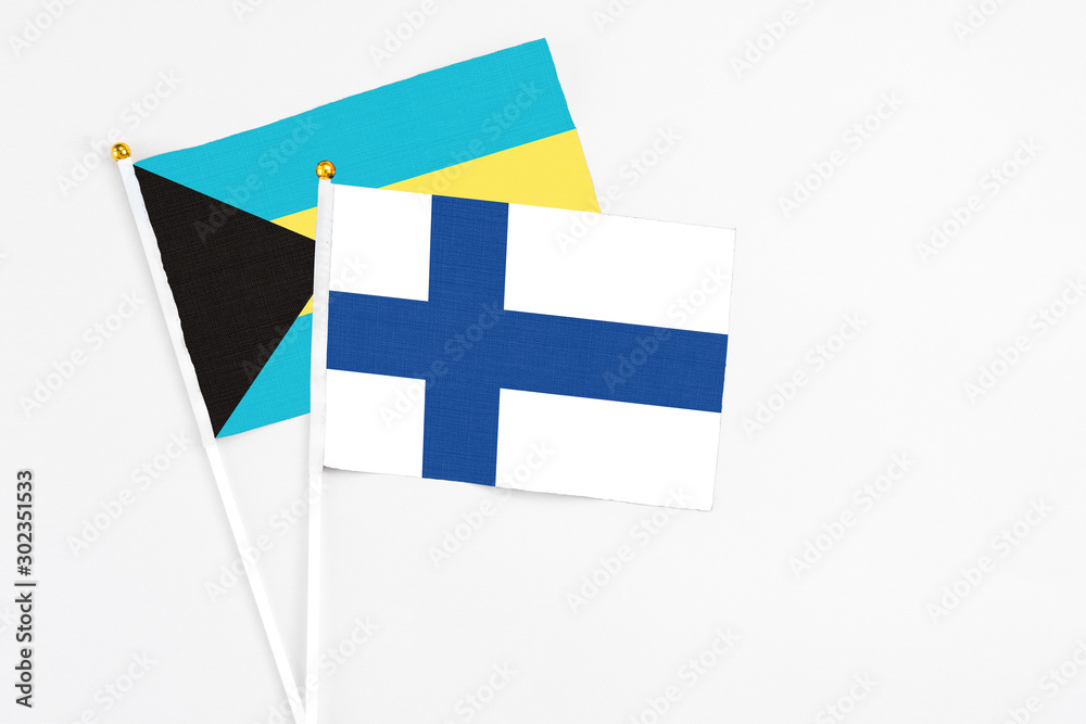 Finland and Bahamas stick flags on white background. High quality fabric, miniature national flag. Peaceful global concept.White floor for copy space.