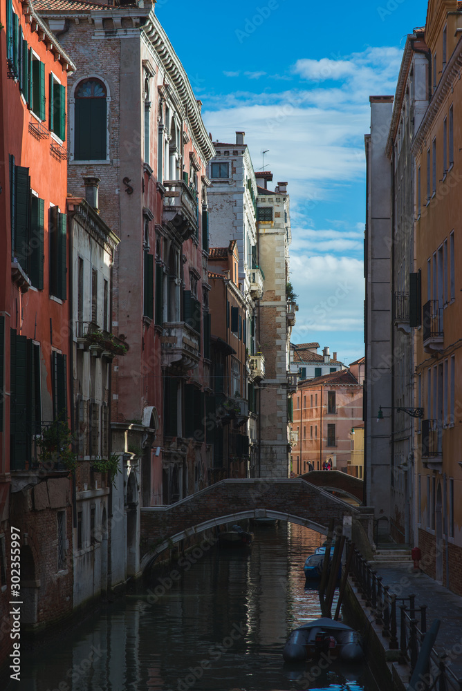 Narrow canal streets in Venice. Traveling in traditional gondolas around the city.