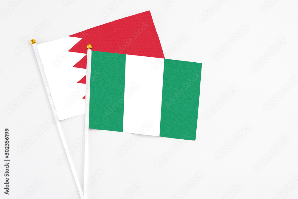 Nigeria and Bahrain stick flags on white background. High quality fabric, miniature national flag. Peaceful global concept.White floor for copy space. Nigeria and Bahrain stick flags on white background. High quality fabric, miniature national flag. Peaceful global concept.White floor for copy space.