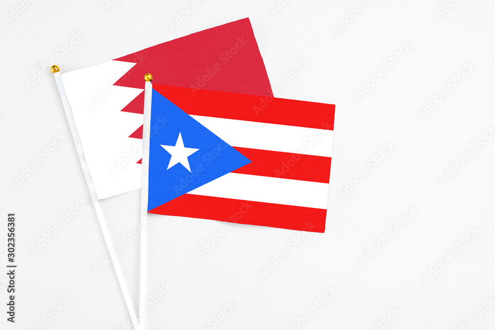 Puerto Rico and Bahrain stick flags on white background. High quality fabric, miniature national flag. Peaceful global concept.White floor for copy space.