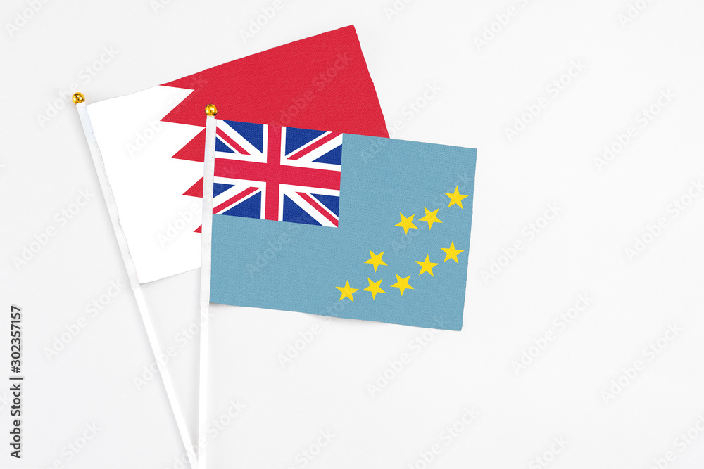 Tuvalu and Bahrain stick flags on white background. High quality fabric, miniature national flag. Peaceful global concept.White floor for copy space. Tuvalu and Bahrain stick flags on white background. High quality fabric, miniature national flag. Peaceful global concept.White floor for copy space.