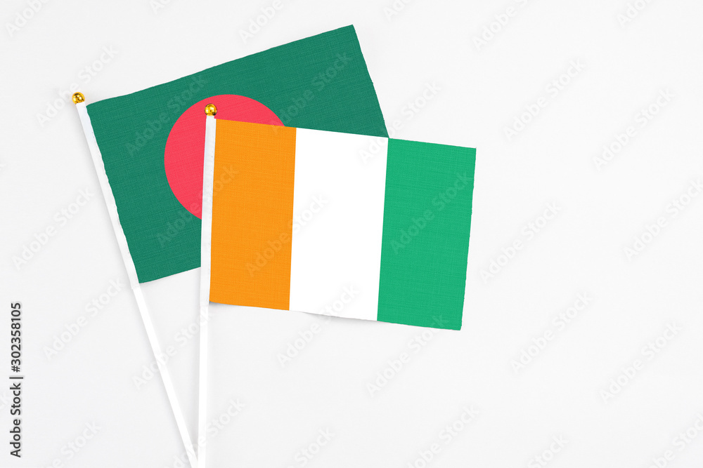 Cote D'Ivoire and Bangladesh stick flags on white background. High quality fabric, miniature national flag. Peaceful global concept.White floor for copy space. Cote D'Ivoire and Bangladesh stick flags on white background. High quality fabric, miniature national flag. Peaceful global concept.White floor for copy space.