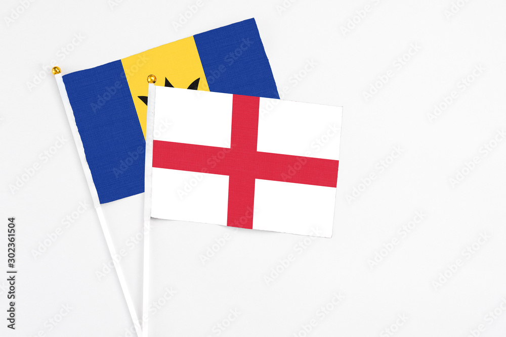 England and Barbados stick flags on white background. High quality fabric, miniature national flag. Peaceful global concept.White floor for copy space.