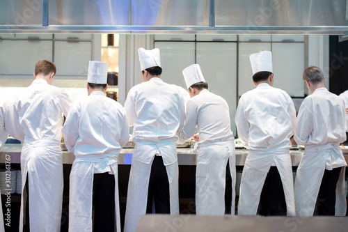 Group chefs busy in commercial kitchen of fine dinning restaurant