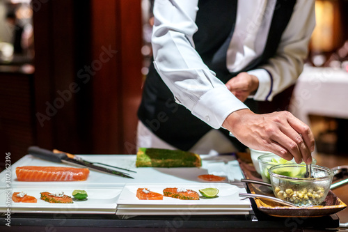 Professional chef decorating salmon for appertize photo