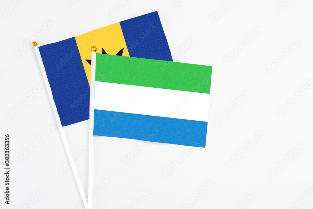 Sierra Leone and Barbados stick flags on white background. High quality fabric, miniature national flag. Peaceful global concept.White floor for copy space. Sierra Leone and Barbados stick flags on white background. High quality fabric, miniature national flag. Peaceful global concept.White floor for copy space.