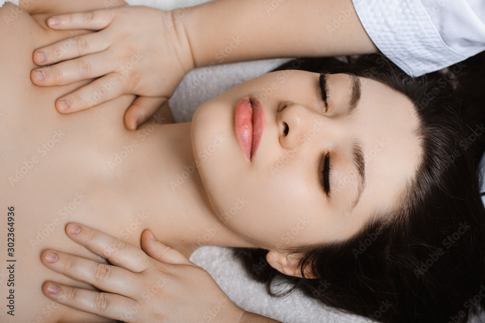 Beautiful young woman having facial massage while being in a wellness spa. Beautiful young woman having facial massage while being in a wellness spa.
