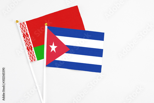 Cuba and Belarus stick flags on white background. High quality fabric, miniature national flag. Peaceful global concept.White floor for copy space. photo