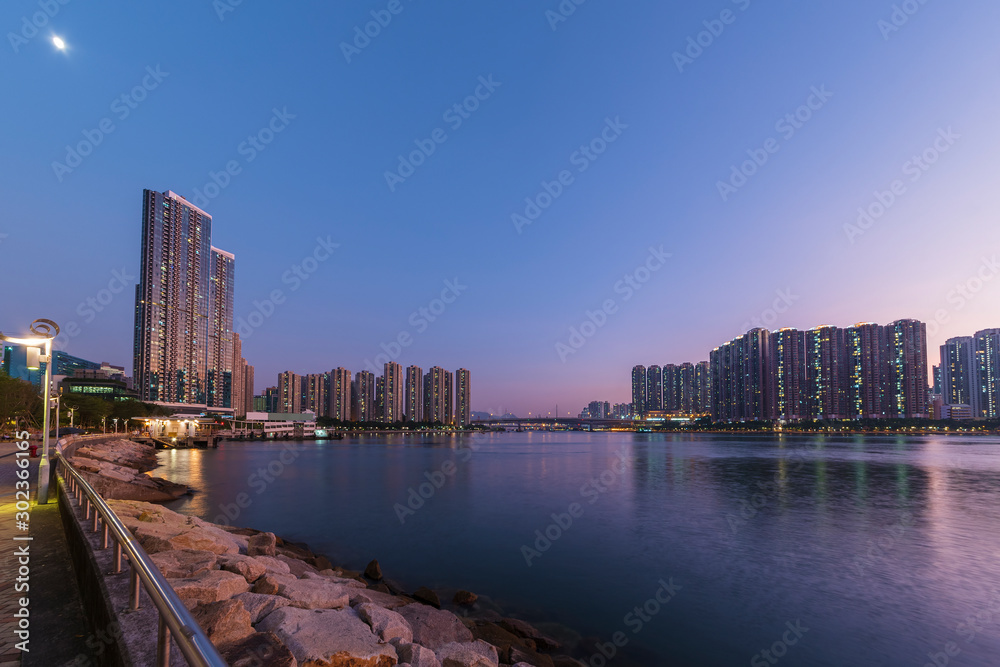 High rise residential building and harbor in Hong Kong city at dusk