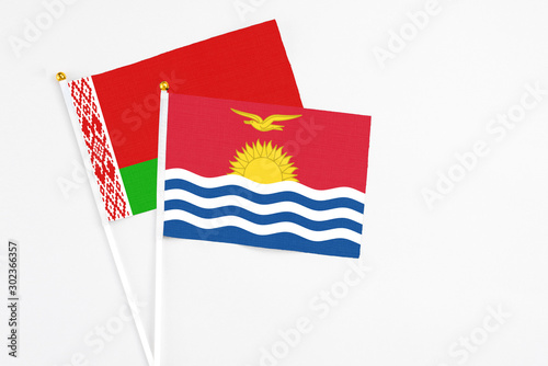 Kiribati and Belarus stick flags on white background. High quality fabric, miniature national flag. Peaceful global concept.White floor for copy space. photo